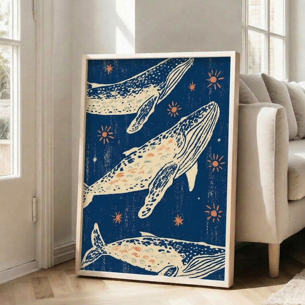 Japandi-inspired framed art print with a whale motif surrounded by celestial suns and stars in navy blue, rust orange, and seafoam green against a calm night ocean palette.