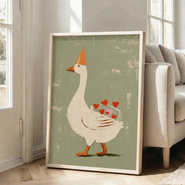 Cottagecore-inspired framed art print featuring a cheerful goose with a festive hat and scattered hearts in muted sage, cream, orange, and brown palette.