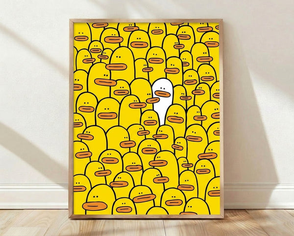 Minimalist pop art poster featuring a crowd of white ducks with one distinctive yellow duck standing out, accented with a glowing halo; framed wall art in bright yellow, orange, and black.