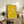 Modern wall poster showing a minimalist composition of white ducks surrounding a singular yellow figure with a radiant halo, evoking themes of individuality and standing out.