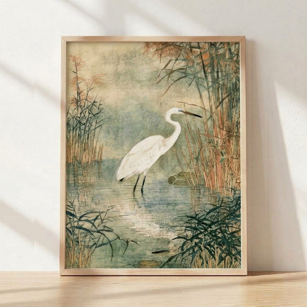 Serene watercolor painting of a white egret standing among reeds and bamboo in soft sage green and dusty blue tones, framed as wall art.