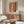 Abstract close-up poster art of a delicate white feather composition with meditative sensuality, rendered in soft cream, terracotta, and warm golden tones.