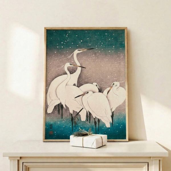 Framed zen wall art featuring snow-covered herons in a serene composition, executed in muted palette of white, gray-blue, and sage green with touches of gold.
