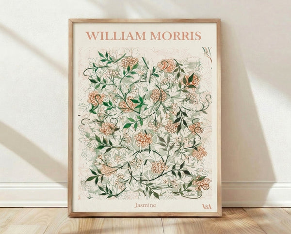 Art Nouveau botanical print featuring jasmine flowers and flowing vines in coral-pink and forest green on a cream background, framed on a wall.