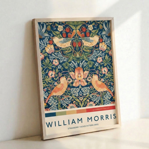 Framed William Morris botanical print displaying birds perched among strawberry vines and blooming flowers in romantic navy and sage palette with ornamental detailing.