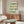 Hand-drawn wine bottle artwork in contemporary pop art style, featuring bold black outlines and a cheerful palette of forest green, orange, and cream tones on framed wall art.