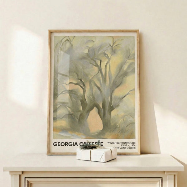 Winter cottonwood trees rendered in gentle watercolor with cream, soft gray, and pale yellow hues, framed on wall in serene, minimalist composition.