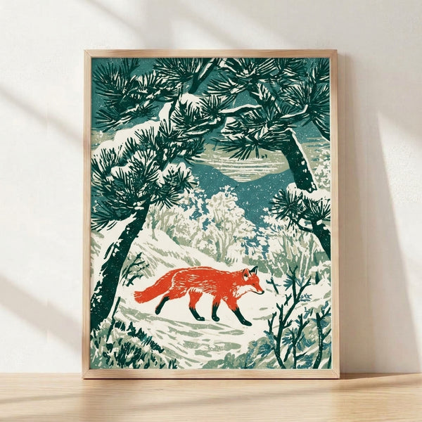 Framed woodblock-style art print depicting a rust-red fox in a snowy pine forest with deep blue mountains, sage green trees, and cream accents in a serene, minimalist Japandi aesthetic.