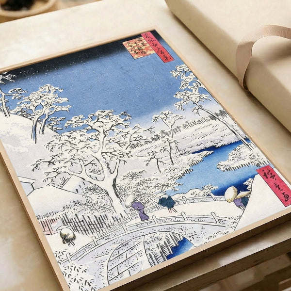 Tranquil ukiyo-e-inspired poster art: snow-blanketed landscape with bridge, river, evergreen forest, and mountainous backdrop in muted burgundy, blue, and cream palette.