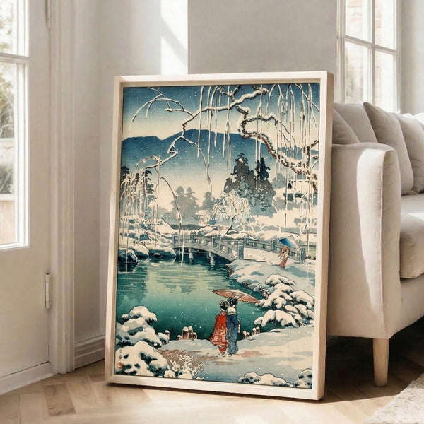Framed woodblock-style poster of a serene snow bridge scene with water, mountains, and atmospheric winter mood in cream, deep teal, and dark blue palette.