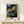 Intimate impressionist scene of a woman bathing, framed as wall art with gentle tonal palette of pale blues, creams, and soft grays.