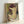 Faceless portrait of a woman with her arm raised while combing her hair, painted in gentle impressionist tones of cream, tan, and shadow.
