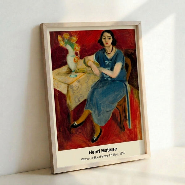 Matisse-style poster art depicting an introspective woman's face in soft blue hues with ochre accents and simplified abstract forms, hung as framed wall decor.