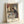Vintage Impressionist framed print showing a woman absorbed in her ironing task, painted in soft ochre and cream with subtle green accents, evoking quiet domestic contemplation.