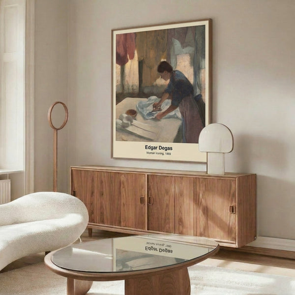 Intimate labor study in Impressionist style depicting a woman leaning over her ironing work, rendered in soft earth tones and creams, displayed as a framed wall print.