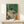 Wabi sabi wall art of a solitary figure absorbed in reading, rendered in muted forest green, pale yellow, and terracotta with understated home comfort details.