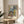 Framed wall art of a woman gazing outward through shuttered windows, alive with serene yet vibrant cobalt, emerald, coral, and yellow tones in modernist composition.