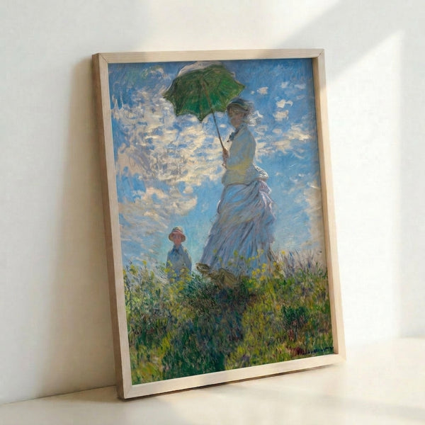 Framed poster depicting a woman and child in a blooming field beneath a parasol, painted in soft Impressionist style with delicate greens and golden light.