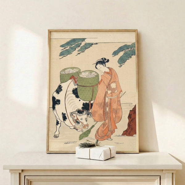 Framed Japanese woodblock print in cream and sage green depicting a woman and cow in a serene countryside scene with woven baskets and folkloric charm.