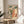 Japanese woodblock poster with a woman in patterned kimono and a cow in an intimate domestic setting, rendered in soft creams and pale blue-greens with bold black details.