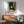 Modern Japandi wall art of a woman in repose with wine, illustrated in sophisticated black linework against teal and cream, infused with wabi-sabi tranquility and interior design sensibility.