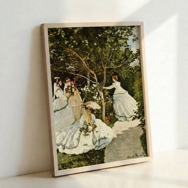 Framed impressionist art print showing elegantly dressed women relaxing in a sunlit garden surrounded by vibrant blooms, painted in soft, atmospheric colors.