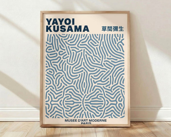 Abstract minimalist poster with repeating geometric patterns in cream and steel blue, creating a meditative hypnotic composition framed on wall.
