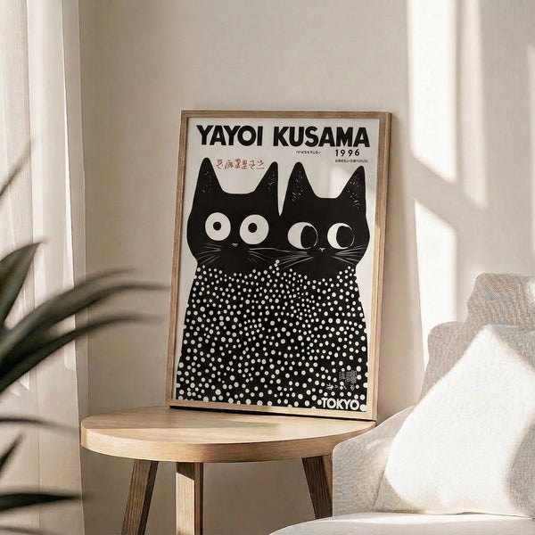 Framed artwork depicting stylized black cats with mesmerizing dot patterns and prominent eyes, blending Japanese artistic traditions with contemporary minimalist design.