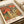 Framed decorative print with surreal mushroom and flower motifs in Japanese-inspired aesthetic, rendered in terracotta, olive, and dusty blue tones.