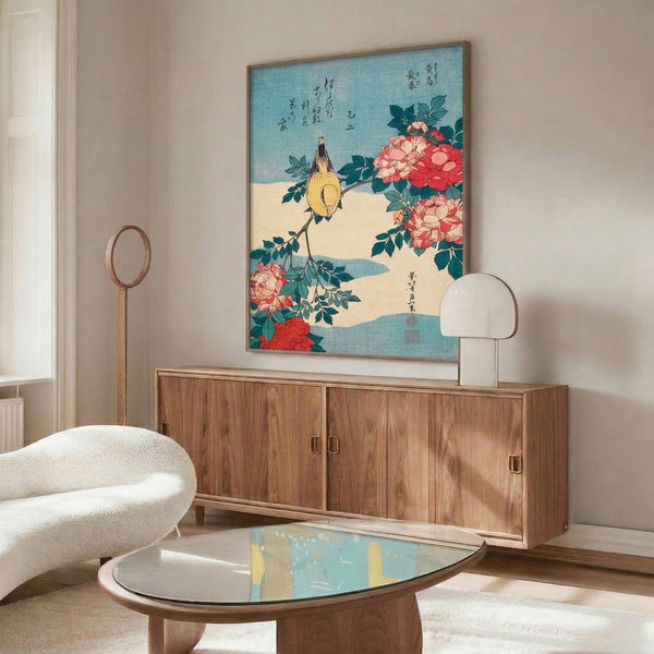 Framed Ukiyo-e style woodblock art of a yellow bird in repose among coral-red peonies with elegant teal foliage and serene cream-colored space.