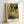 Vintage impressionist poster of ballet dancers in glowing yellow and cream, with pale blue accents, conveying gentle movement and theatrical elegance.