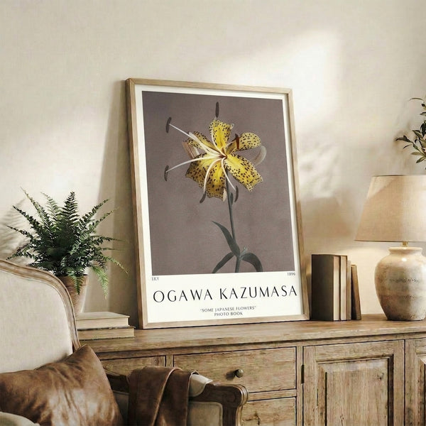 Japanese botanical print of a graceful lily with spotted petals in warm yellow hues and muted green leaves, presented as a framed wall art piece.