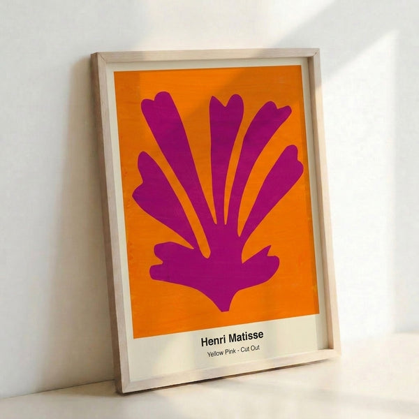 Framed wall art displaying organic yellow and pink cut-out shapes against white, evoking playful abstraction with a serene, contemporary aesthetic.