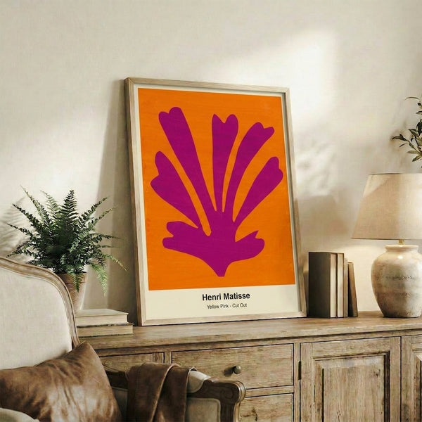 Framed abstract artwork featuring bold yellow and pink cut-outs arranged in a balanced composition that feels both spontaneous and thoughtfully minimal.