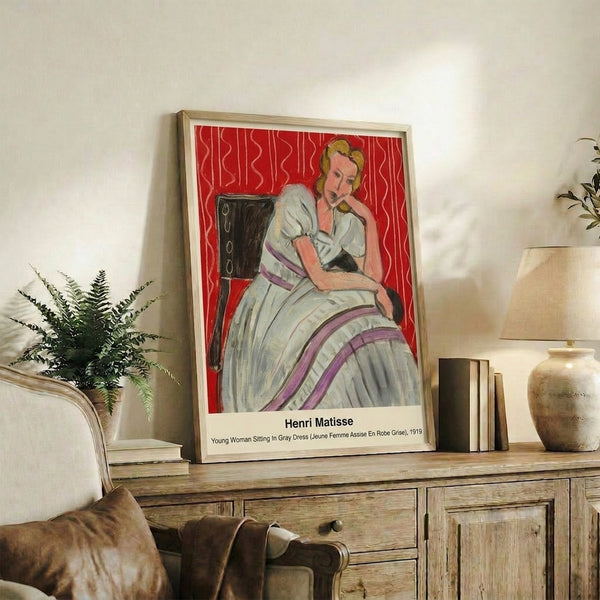 Soft watercolor-style framed poster of an introspective woman in gray, surrounded by vibrant wallpaper motifs in violet hues, capturing an intimate moment in the Modern Impressionist tradition.